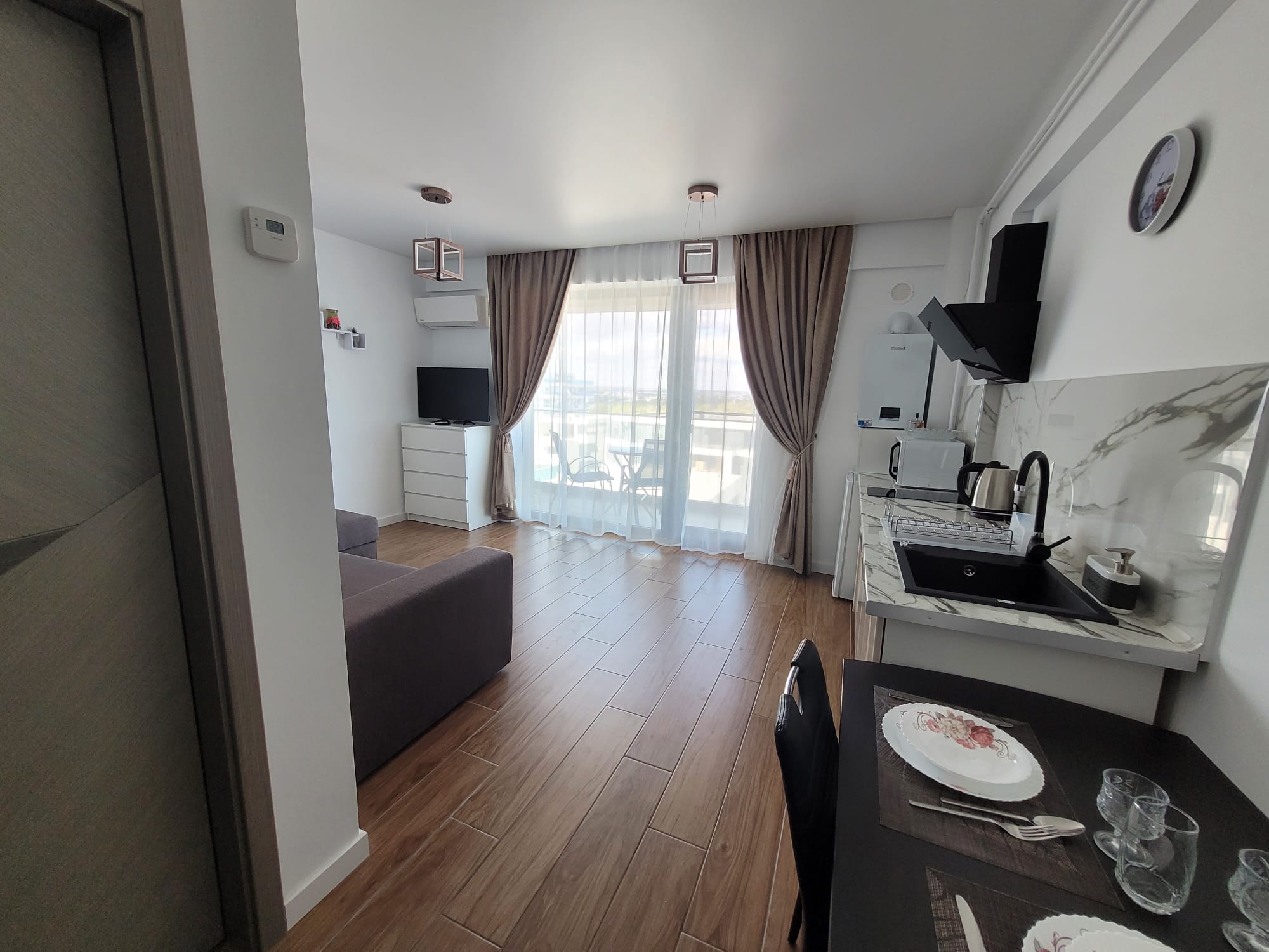 Bucătăria — complet utilată, cu frigider, microondă și mobilier modern